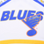 Close-up of blue Blues lettering and St. Louis musical note logo on white fabric