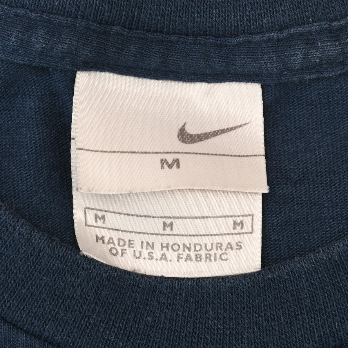 Nike neck tag showing Swoosh logo and medium size marking
