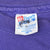 Close-up of Hanes neck label marked Large and Made in USA on purple T-shirt