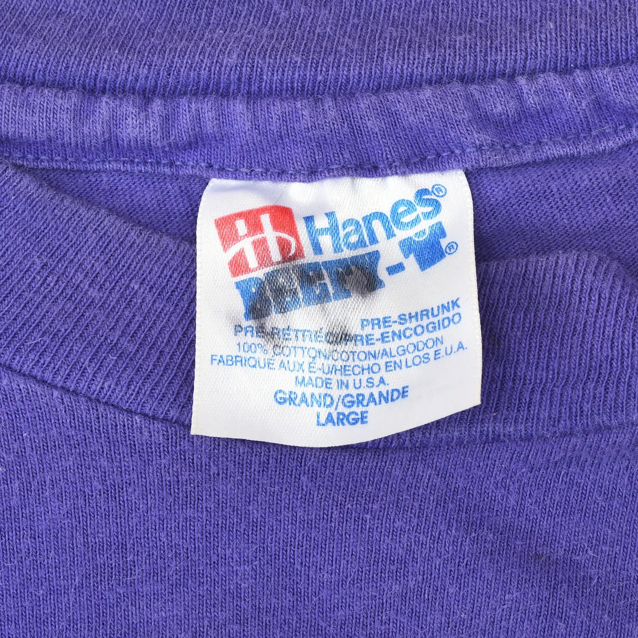 Close-up of Hanes neck label marked Large and Made in USA on purple T-shirt