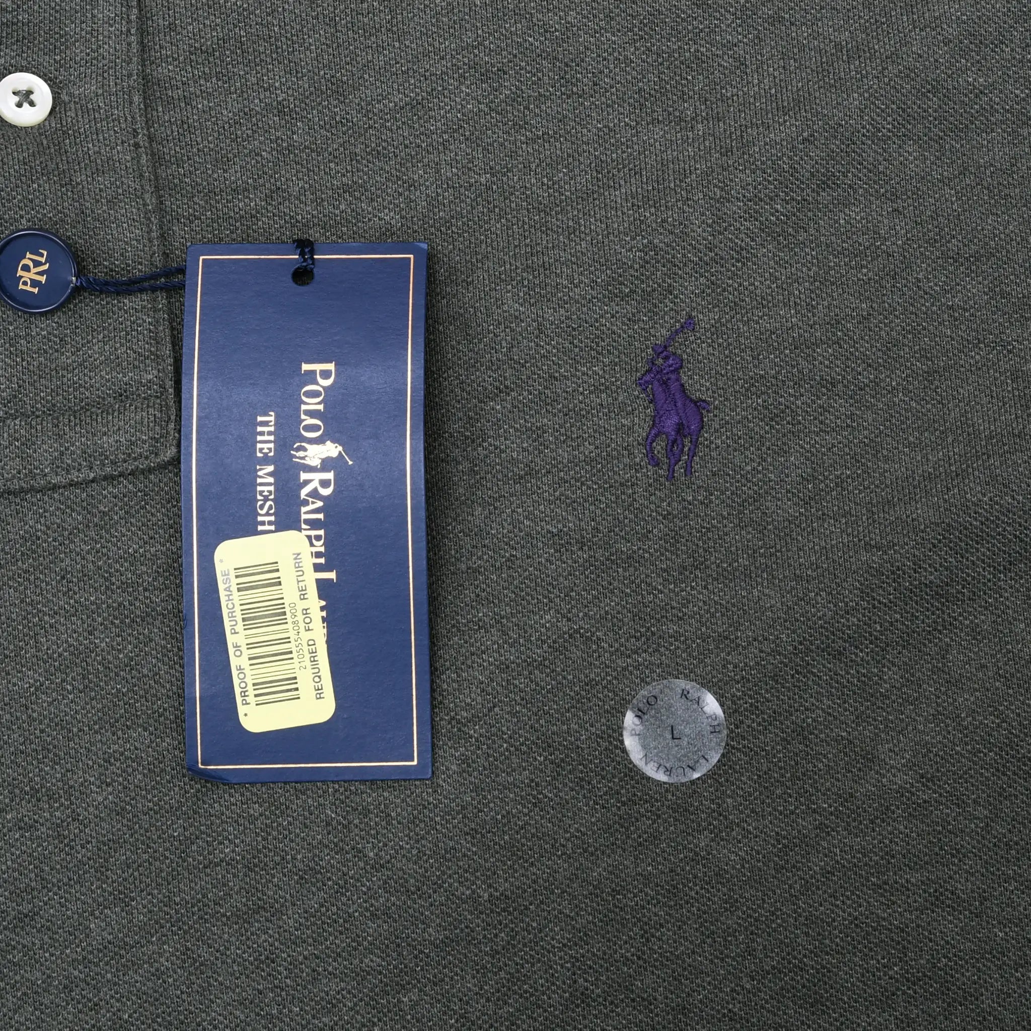 Purple embroidered Polo pony logo and attached Polo Ralph Lauren hangtag on green fabric