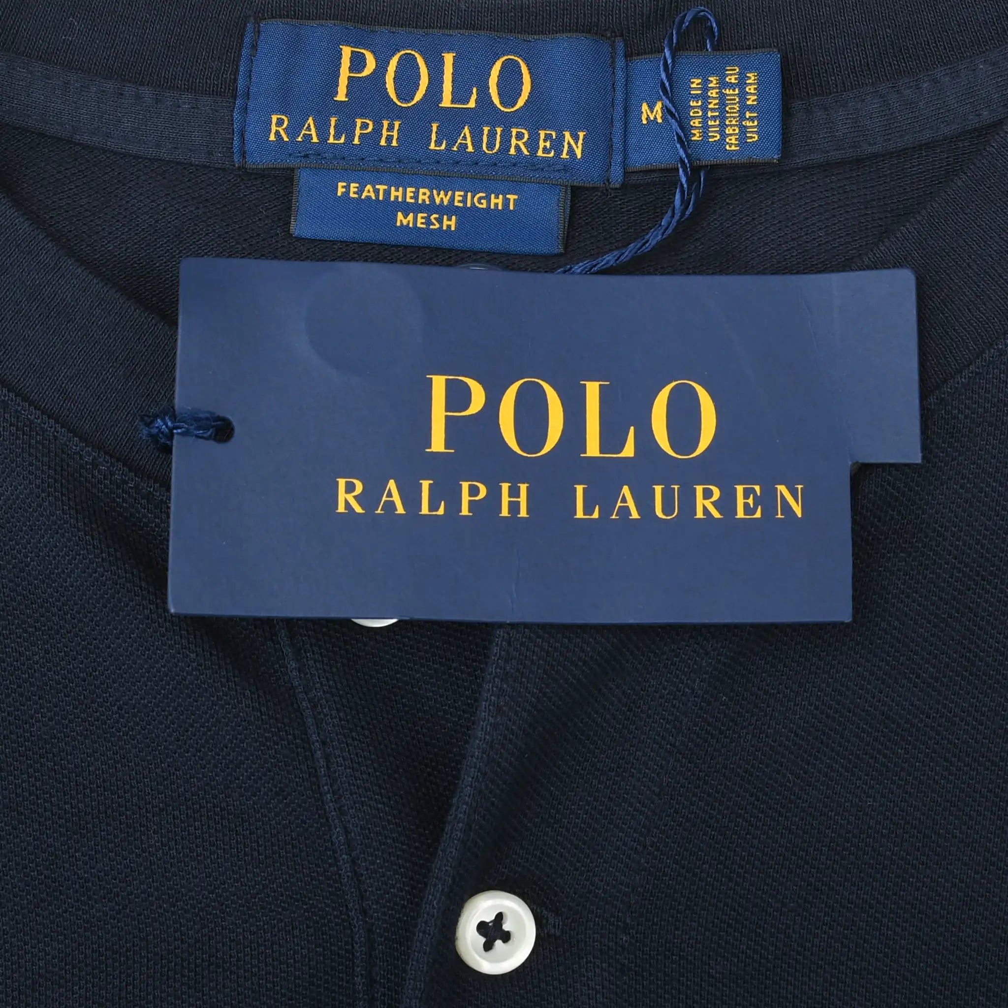Polo Ralph Lauren neck label, medium size tag, and hangtag on navy Henley shirt