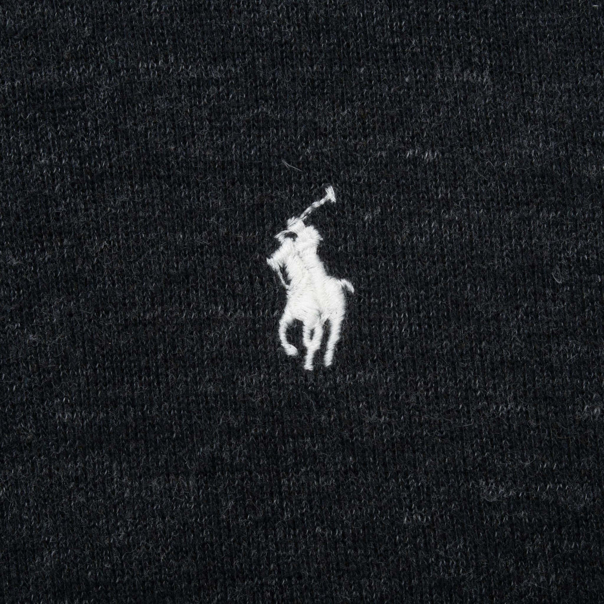 Close-up of white Polo Ralph Lauren pony embroidery on dark grey sweater fabric