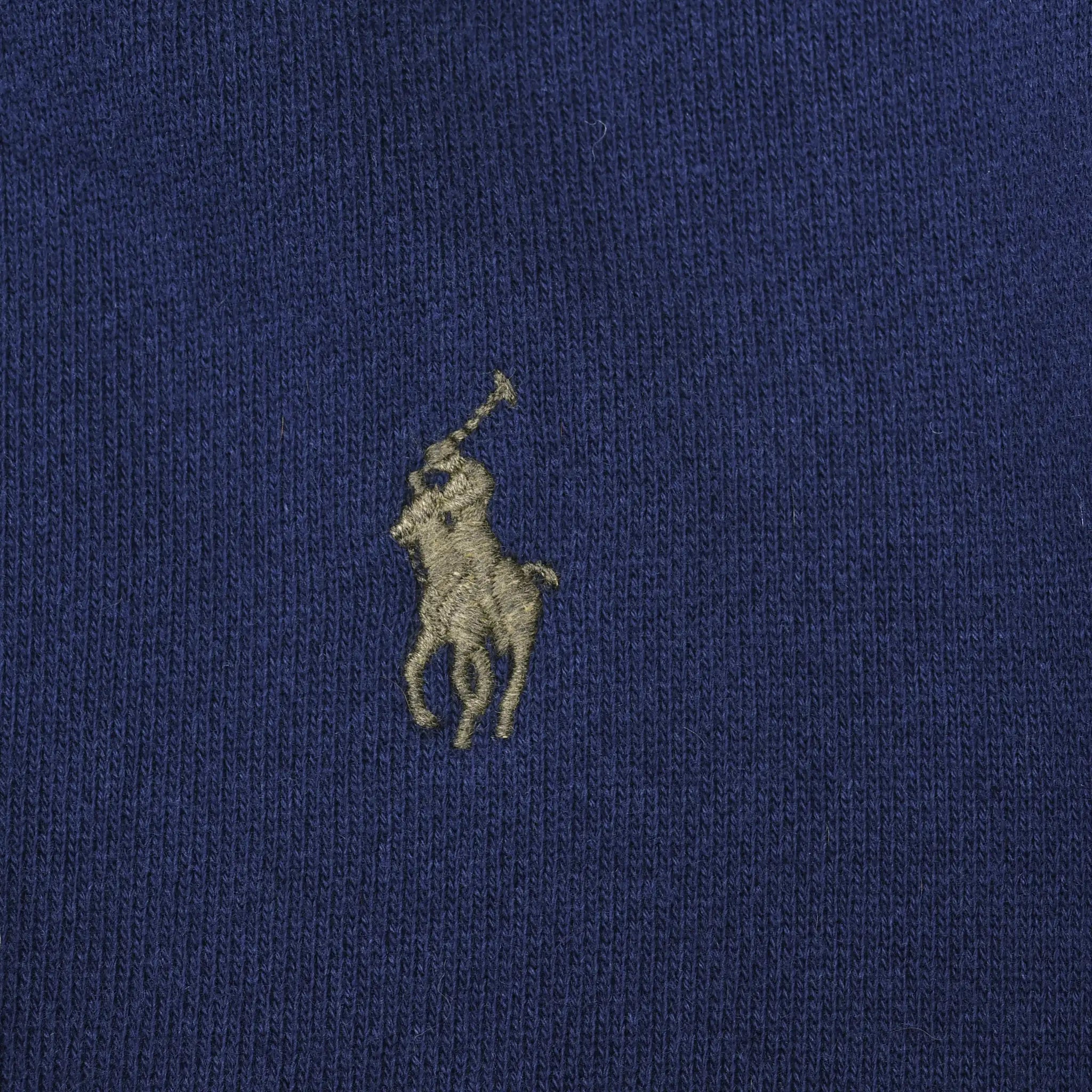 Close-up of embroidered Polo pony logo on navy blue sweatshirt fabric