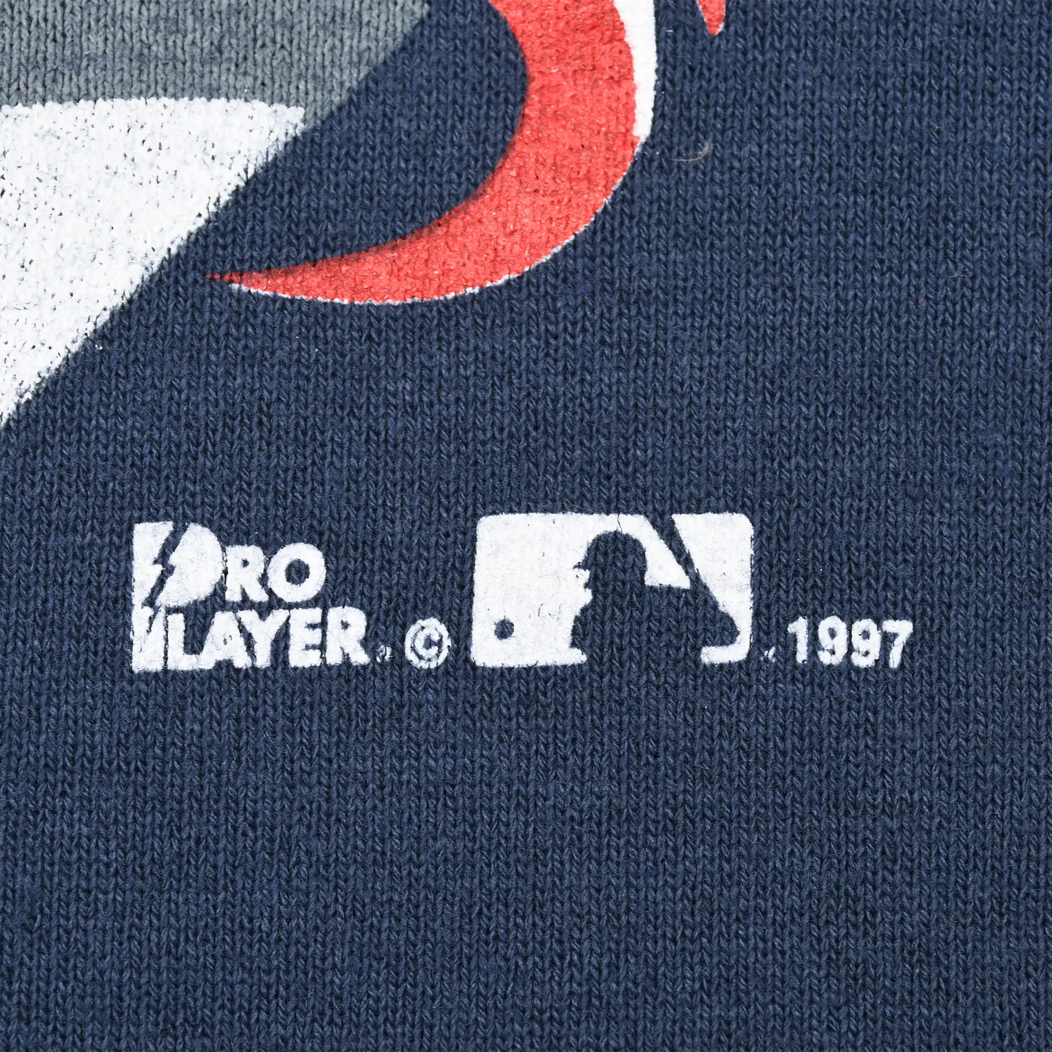 Close-up of Pro Player, MLB and 1997 copyright marks printed on navy fabric