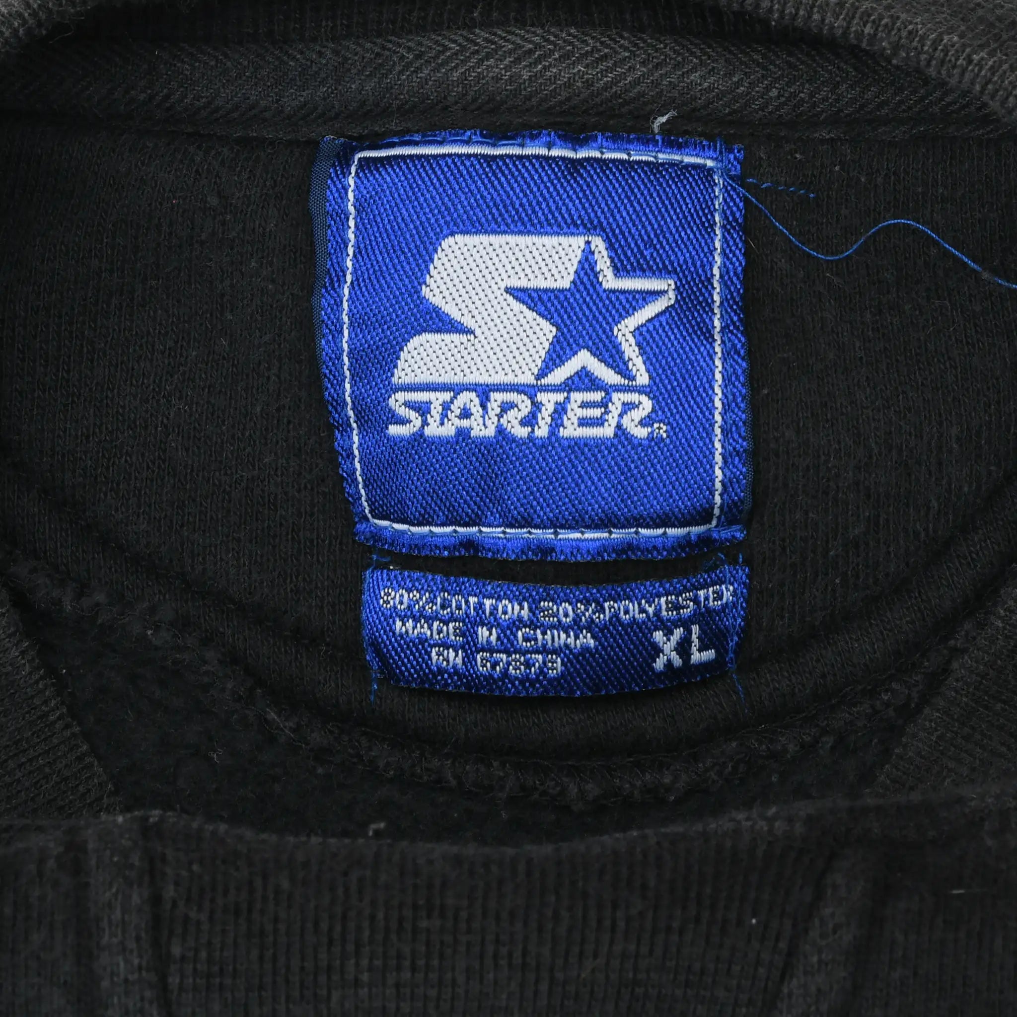Close-up of blue Starter neck label marked XL inside black sweatshirt