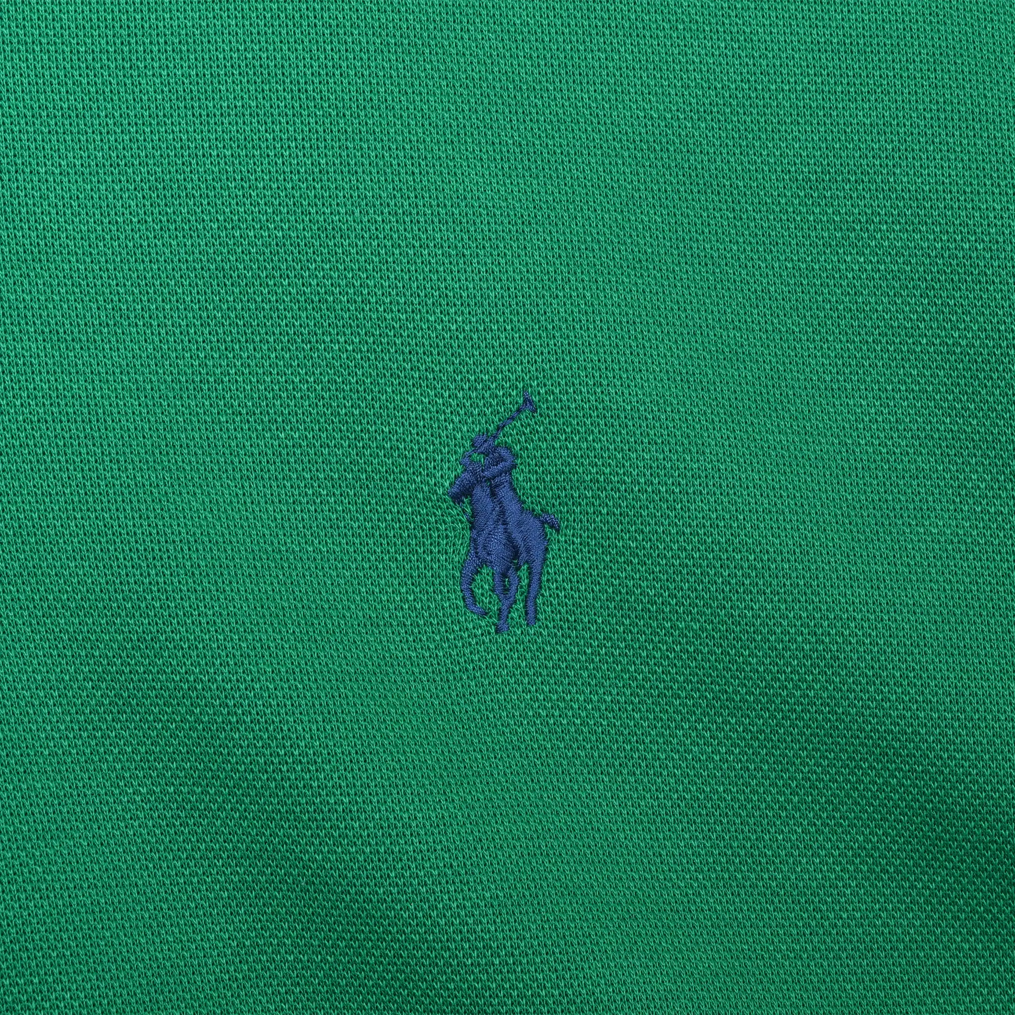 Close-up of navy Polo pony embroidery on green sweater