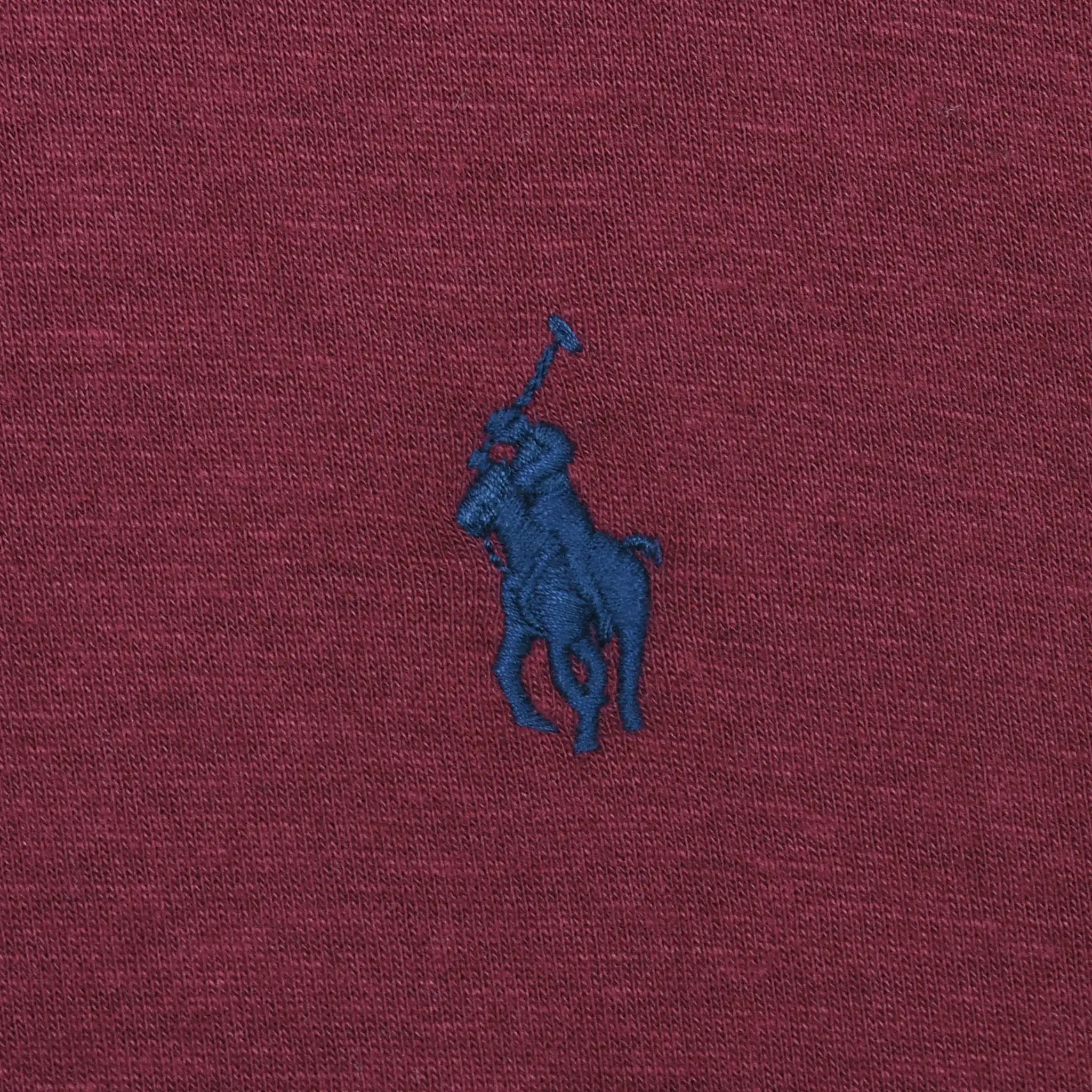 Close-up of navy Polo pony embroidery on burgundy fabric