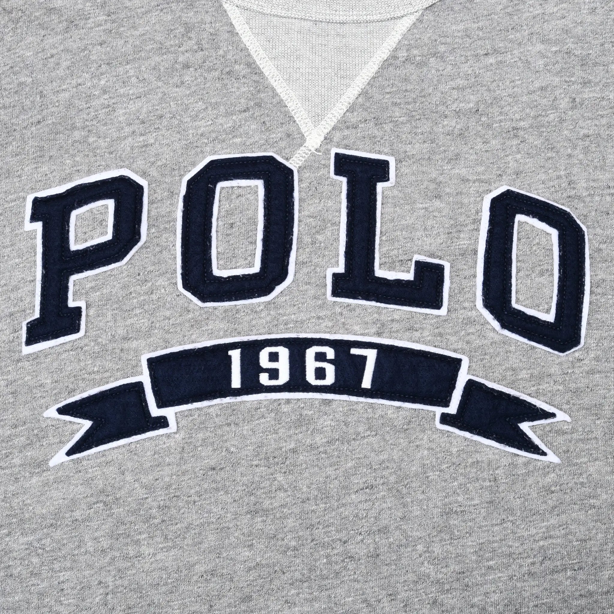 Close-up of navy and white POLO 1967 chest embroidery on grey sweatshirt