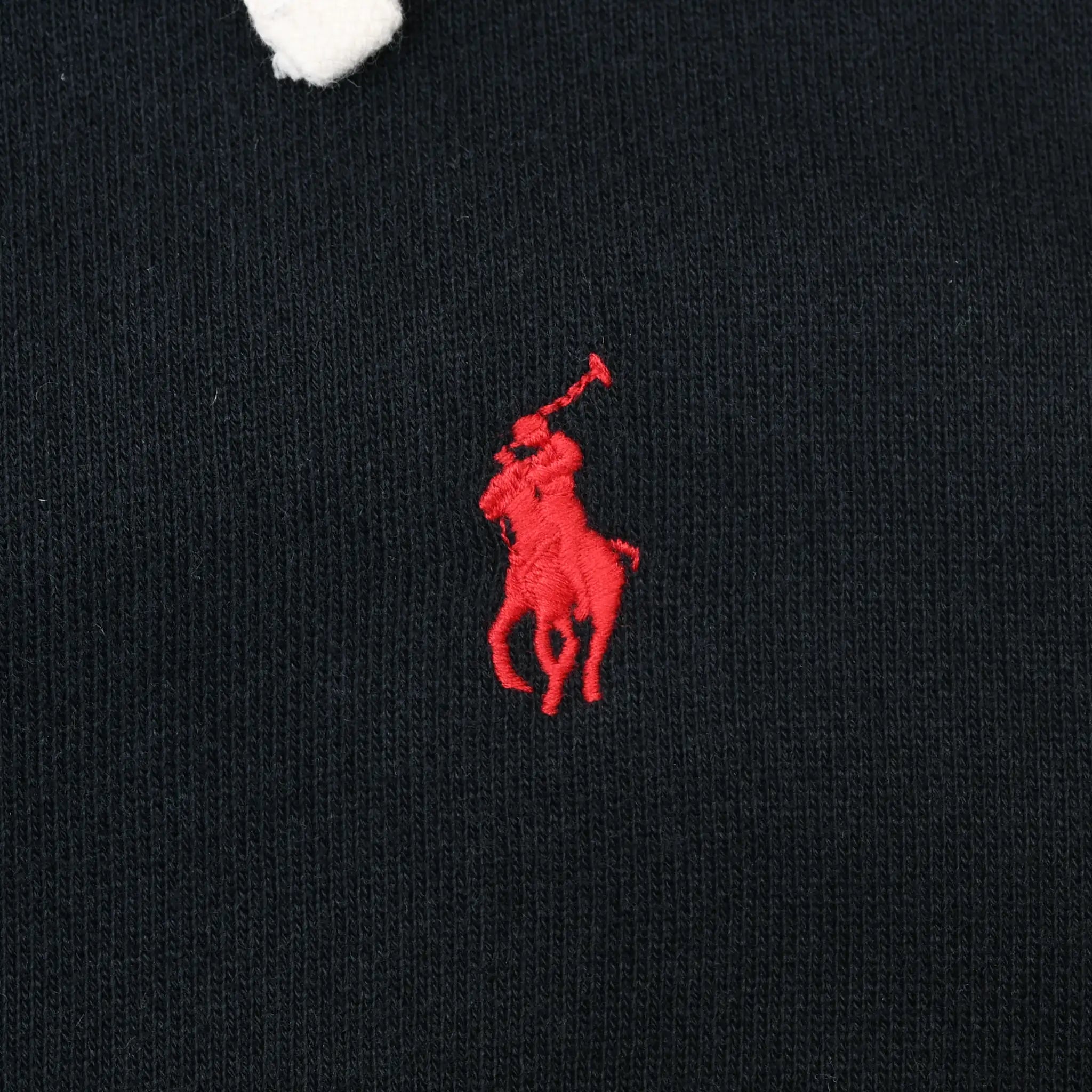 Close-up of red Polo pony embroidery on black hoodie chest