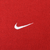Close-up of small white Nike Swoosh embroidery on red sweatshirt fabric