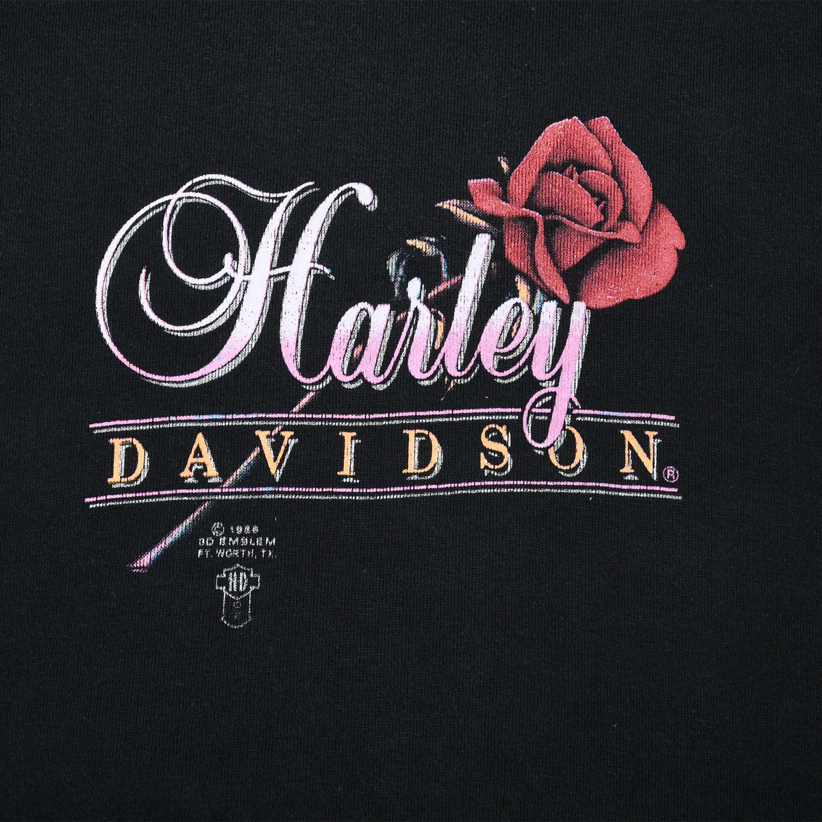 Close-up of Harley-Davidson script and red rose chest print on black fabric