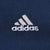 Close-up of white Adidas logo embroidery on navy blue hoodie chest