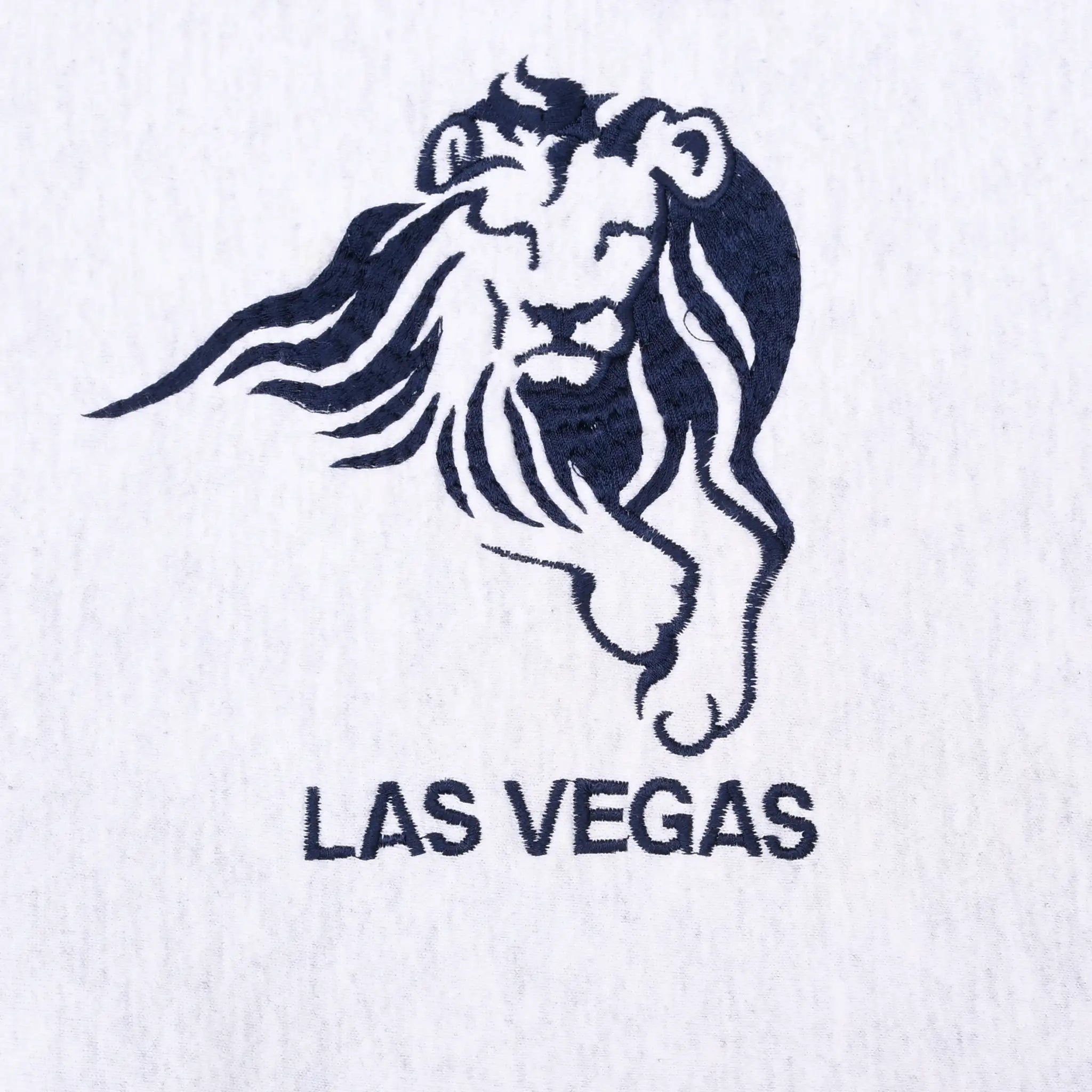 Close-up of navy MGM Grand lion embroidery above Las Vegas text