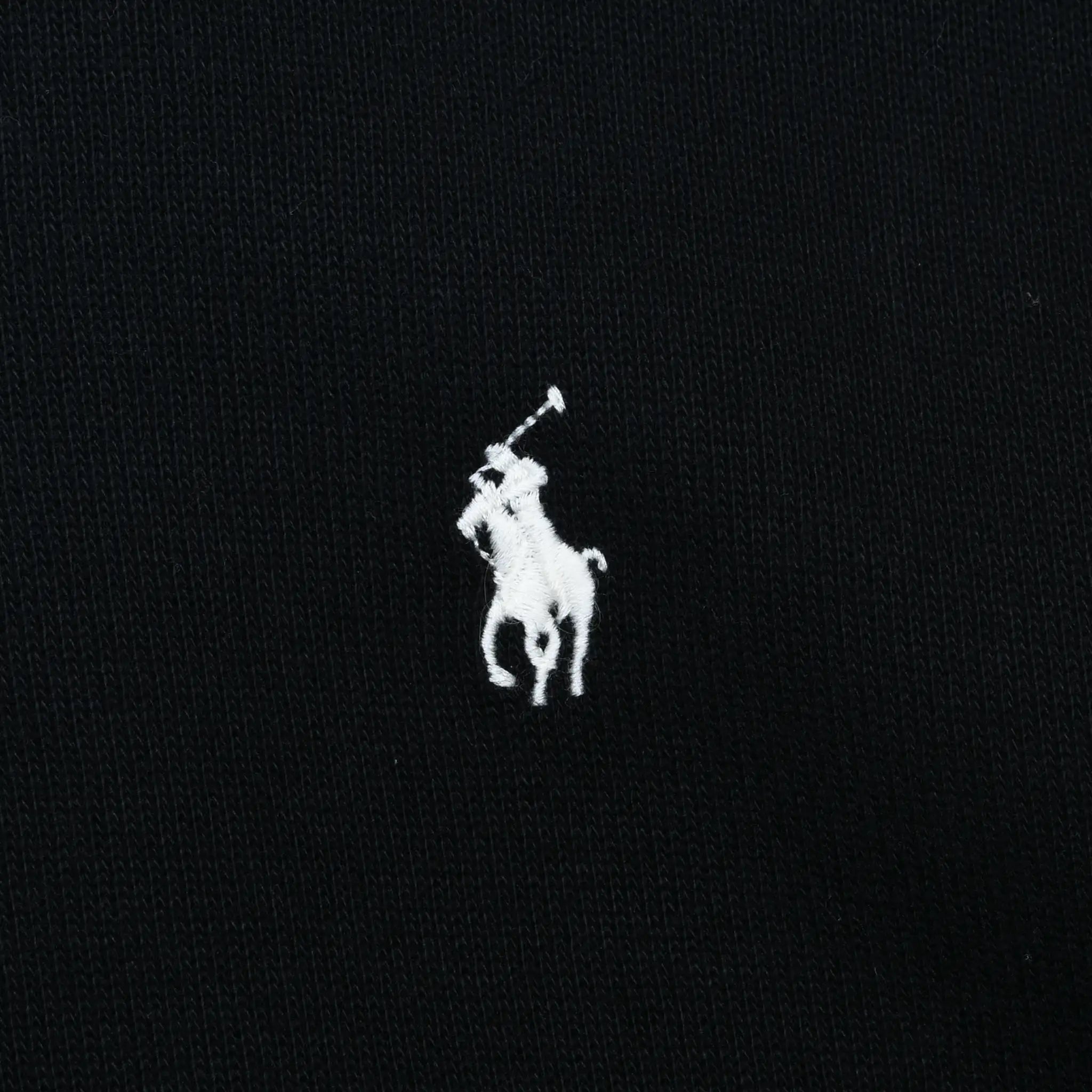 Close-up of white Polo pony embroidery on black sweater
