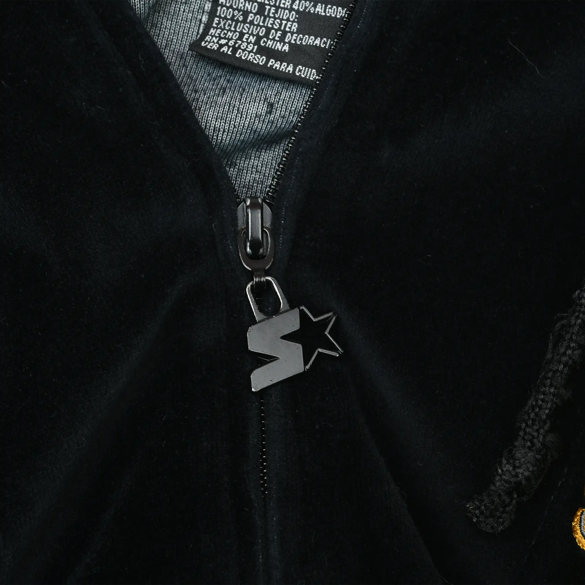 Close-up of black zipper with Starter star logo pull on velvet hoodie
