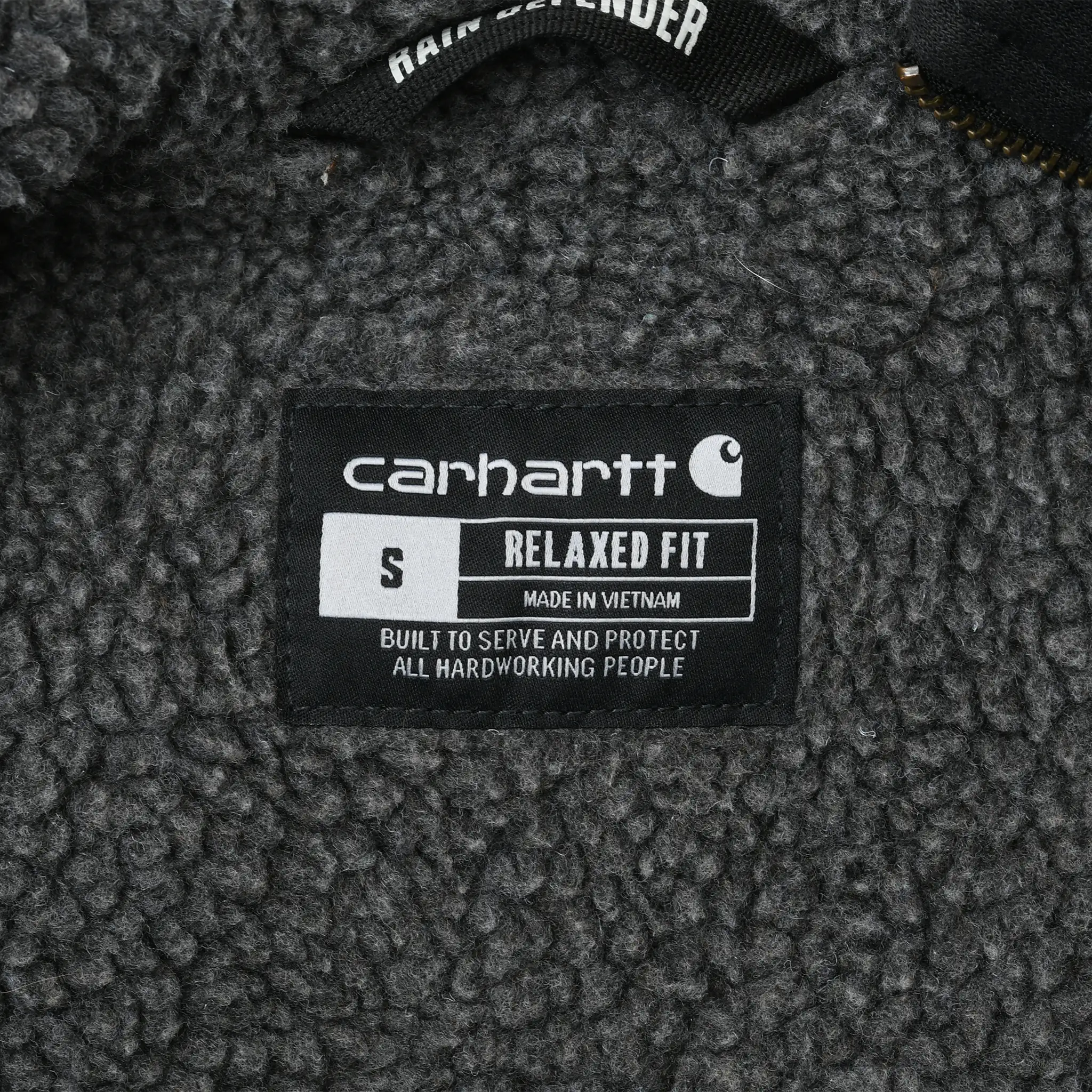 Carhartt interior label showing small size and relaxed fit against gray sherpa lining