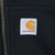 Close-up of Carhartt logo patch beside the zipper on the front pocket