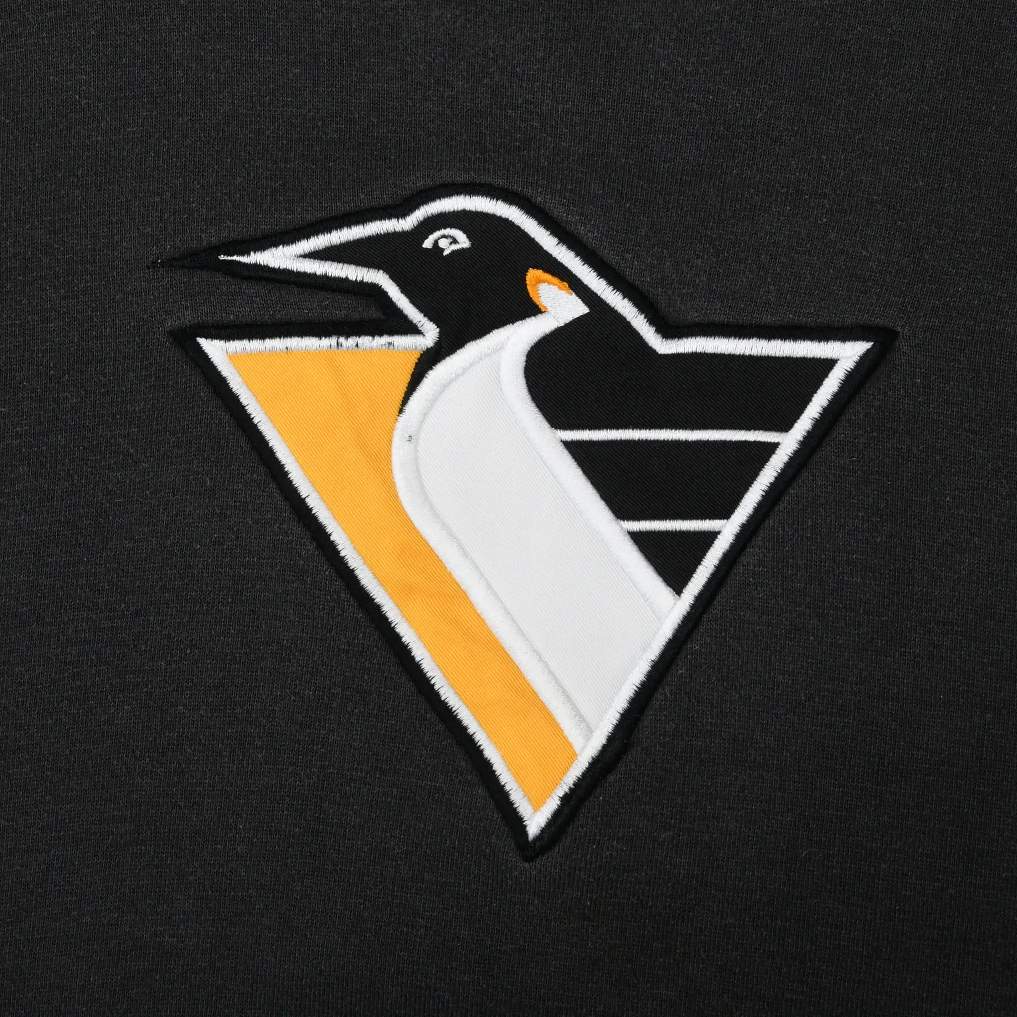 Close-up of embroidered Pittsburgh Penguins logo on black sweatshirt