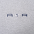Close-up of navy Air lettering and white Nike Swoosh embroidery on grey fabric