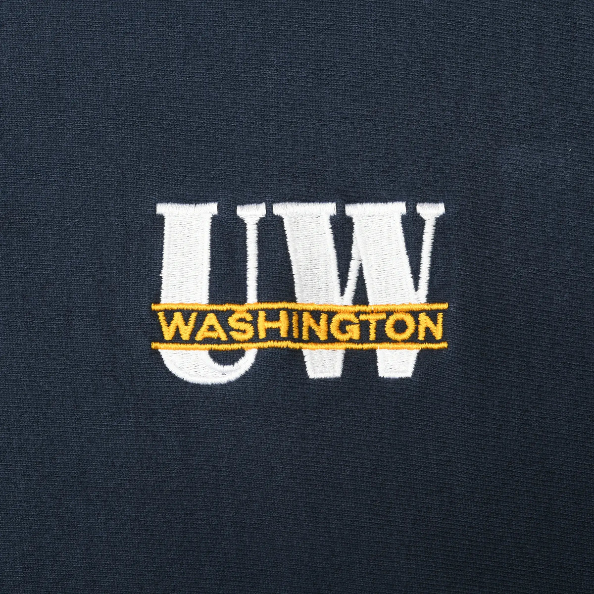 Close-up of white UW and gold Washington chest embroidery on navy sweatshirt