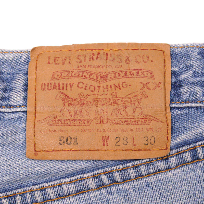 Beautiful Indigo Levis 501 Jeans 1990s Made in USA with a light blue wash and some nice light whiskers.  Size on Tag 28X30  ACTUAL SIZE 26X29  Back Button #553